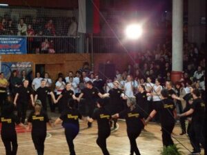 Хоро на начинаещата група на клуб „Нашенци“ – Русе в черни тениски пред публиката в спортна зала „Дунав“, Коледно надиграване 2011
